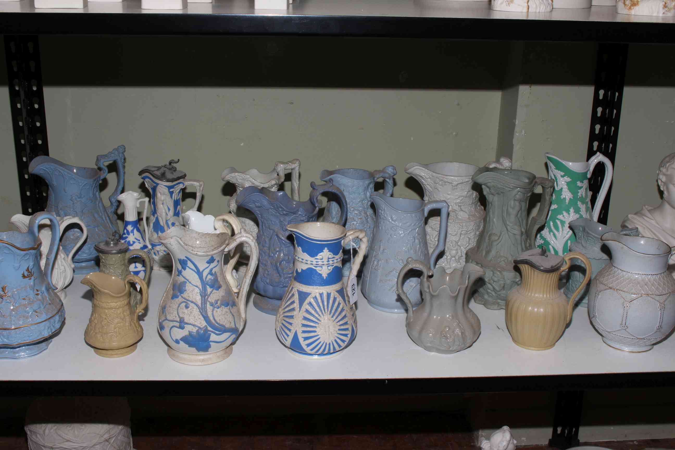 Collection of twenty one Victorian relief moulded jugs, mostly stoneware including Charles Meigh,