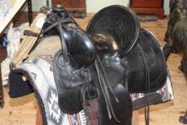 Black leather Western saddle, circa 1896, together with accessories.