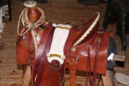 Brown handmade leather saddle together with accessories.