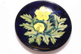 Small Moorcroft dish depicting yellow flowers on blue background, 12cm.