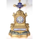 Gilt metal and enamel decorated mantel clock on gilt and upholstered base.