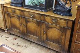 Period style oak dresser having three drawers above three arched fielded panel doors, 79cm by 168cm.