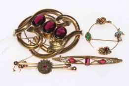 Collection of four stone set brooches including Victorian scroll brooch.