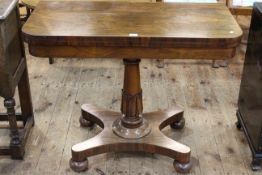 Victorian rosewood fold top card table raised on turned pedestal to inverted quadriform base,