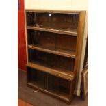 Oak four height sliding glazed door stacking bookcase, 140cm by 89cm.