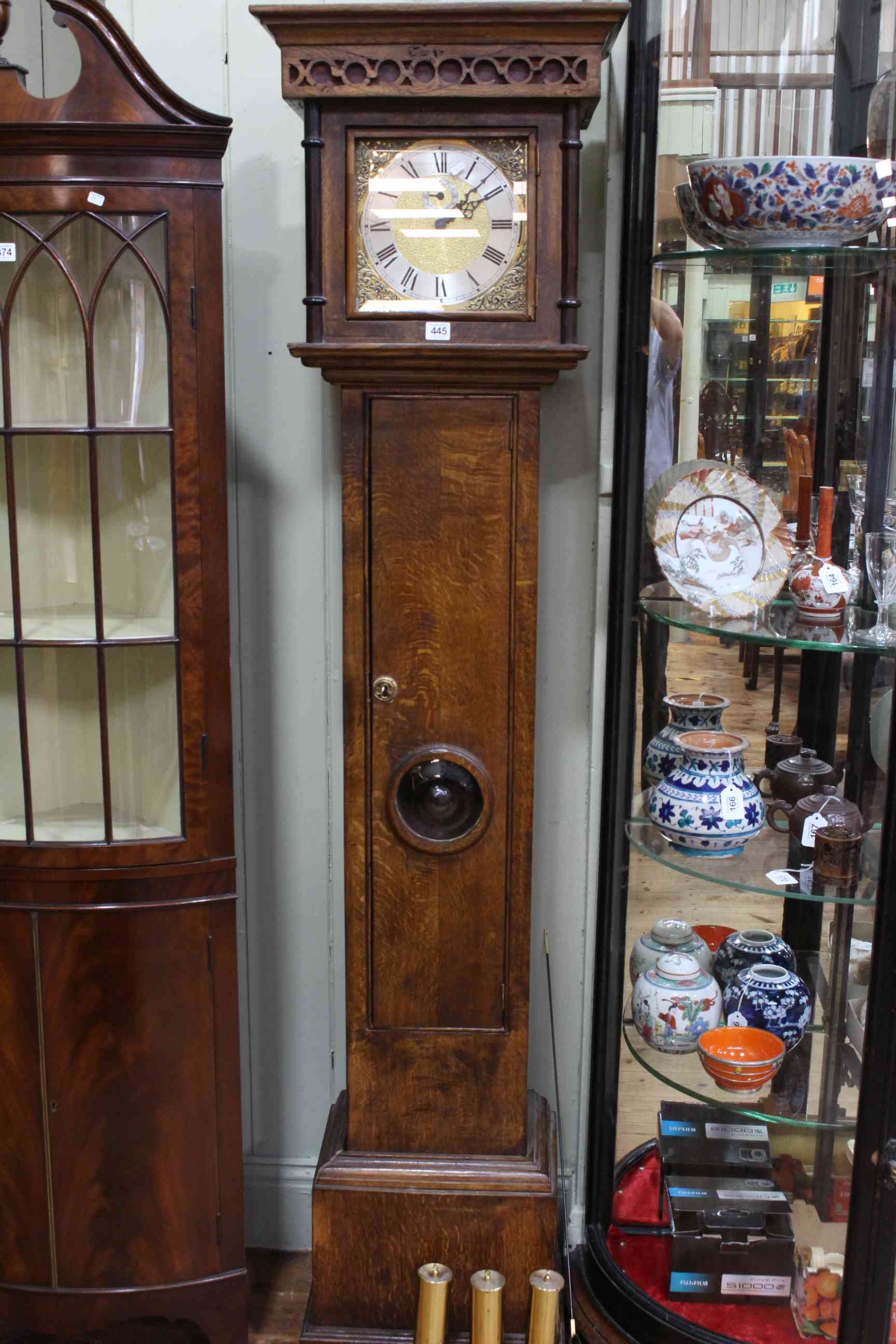 Oak triple weight longcase clock having square brass and silvered dial.