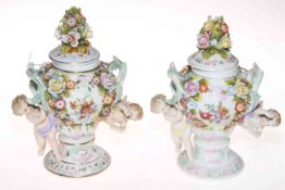 Pair Continental porcelain cherub and flower encrusted vases and covers, 18cm.