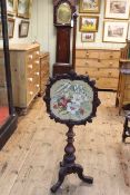 Victorian mahogany tripod pole screen having glazed floral needlework adjustable panel.