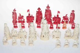 Intricately carved ivory chess set, red stained and plain, lacking one pawn.