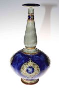 Royal Doulton stoneware vase, the bulbous body with four relief foliate panels on blue ground,