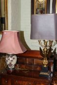 Ornate gilt metal eagle column table lamp and pottery table lamp with shade.