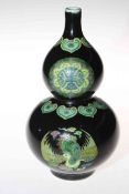Chinese double gourd vase with panels of famille verte on black ground,