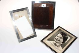 Three rectangular silver photograph frames, approximately 23cm by 14-18cm.