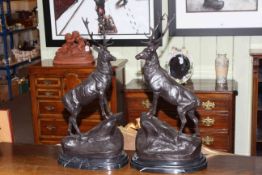 Pair of large impressive bronzes of stags on rocky outcrops, raised on marble plinths, 75cm high.