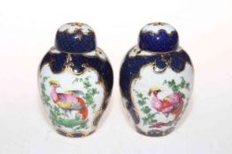 Pair of Worcester style Sampson vases and covers, with panels of birds in ornate gilt borders,