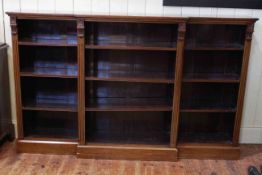 Late Victorian walnut breakfront open bookcase on plinth base with nine adjustable shelves,