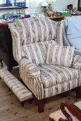 Reclining wing armchair in classical striped fabric and matching long stool.