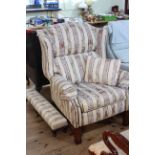 Reclining wing armchair in classical striped fabric and matching long stool.