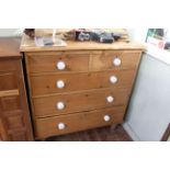 Pine chest of two short above three long graduated drawers on turned legs, 110cm by 104cm.