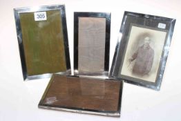 Four rectangular silver photograph frames.