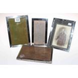 Four rectangular silver photograph frames.