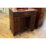 Georgian style mahogany kneehole desk having frieze drawer above a central inset cupboard door
