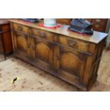 Period style oak dresser having three drawers above three arched fielded panel doors, 79cm by 168cm.