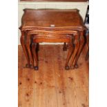 Burr walnut nest of three serpentine form tables on ball and claw legs (largest 56cm by 61cm).