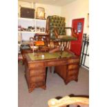 Mahogany eight drawer pedestal desk, green buttoned leather swivel desk chair and desk lamp (3).