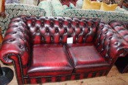 Ox blood buttoned leather two seater Chesterfield settee, 169cm long by 74cm high by 87cm deep.