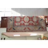 Traditional wool carpet with geometric pattern on rose ground, 3.59 by 2.72.