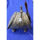 Ornate embossed brass coal scuttle with shovel.