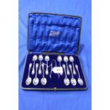 Cased set of twelve silver teaspoons with tongs having pierced and engraved handles, Sheffield 1912.