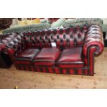 Ox blood buttoned leather three seater Chesterfield settee, 202cm long by 74cm high by 87cm deep.