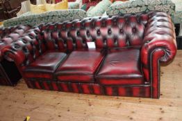 Ox blood buttoned leather three seater Chesterfield settee, 202cm long by 74cm high by 87cm deep.