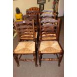 Set of six rush seated ladder back dining chairs.