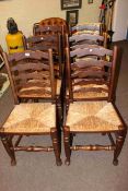 Set of six rush seated ladder back dining chairs.