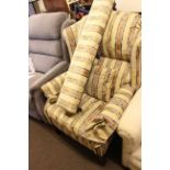 Reclining wing chair in classical striped fabric and matching long stool.