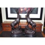 Large impressive pair of bronze stags standing on rocky outcrops raised on marble plinths.