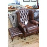 Brown deep buttoned leather wing back chair and footstool.