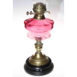 Victorian brass oil lamp with ruby glass reservoir.