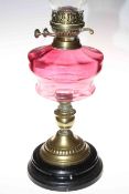 Victorian brass oil lamp with ruby glass reservoir.