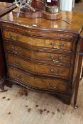 Burr walnut and mahogany serpentine front chest having brush slide above four long drawers on