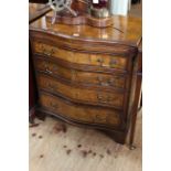 Burr walnut and mahogany serpentine front chest having brush slide above four long drawers on