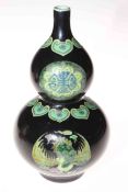 Chinese double gourd vase with panels of famille verte on black ground, 23cm.