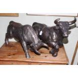 Pair of composite model bulls, 64cm and 57cm.