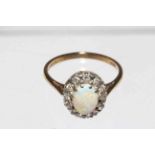 Opal and twelve stone diamond ring set in 9 carat gold, size N.
