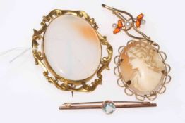 Three 9 carat gold brooches, and scroll bordered onyx brooch (4).