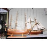 Two handmade wooden galleons on stands.