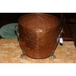 19th Century copper jardiniere with twin brass handles raised on three brass paw feet.